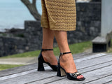 Classy European women's sandals with gold bit detail. Enclosed heel style on chunky block heel. Wedding or special occasion slide. In black.