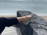 A person wearing a pair of taupe Aerobics Lockheed 1 ballet shoes with a contoured insole and a lightweight rubber sole . Quality European women's footwear made from soft leathers.