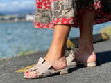 Quality European women's slide sandal. Soft leather with frill trim. In taupe