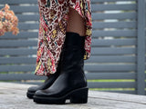 Black ankle boots with a high shine leather finish, featuring a high top line and a robust rubberized tractor sole. European handmade in Portugal with quality leathers and rubber platform sole unit. Beautiful women's boots