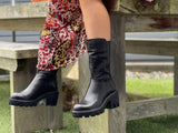 Black ankle boots with a high shine leather finish, featuring a high top line and a robust rubberized tractor sole. European handmade in Portugal with quality leathers and rubber platform sole unit. Beautiful women's boots