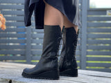 A pair of black mid calf ankle boots with a full inside zip and stitched decorative lace detail on the back of the calf. Wedge platform sole unit. Women's shoes, European made in Portugal from quality leather. Comfortable boots.