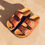 Quality European women's sandals. Made in Spain contoured cork footbed and rubber sole. Comfortable slide style sandal with double buckle detail. Birkenstock style sandal in tan.