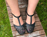 Comfortable T-bar sandals with intricate lasercut detailing. Small heel, contoured footbed. In black.
